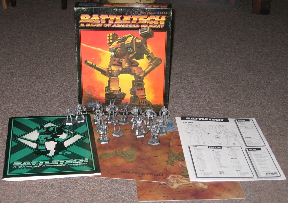 The Battletech 3rd edition box, stood upright, with its contents displayed on front of it.