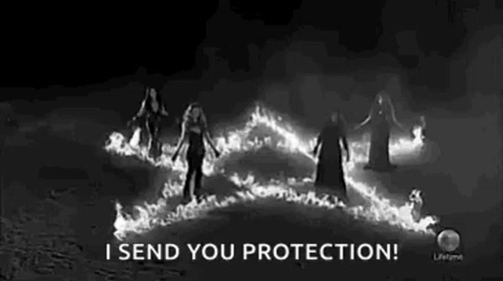 a black and white photo of a group of witches surrounded by flames .