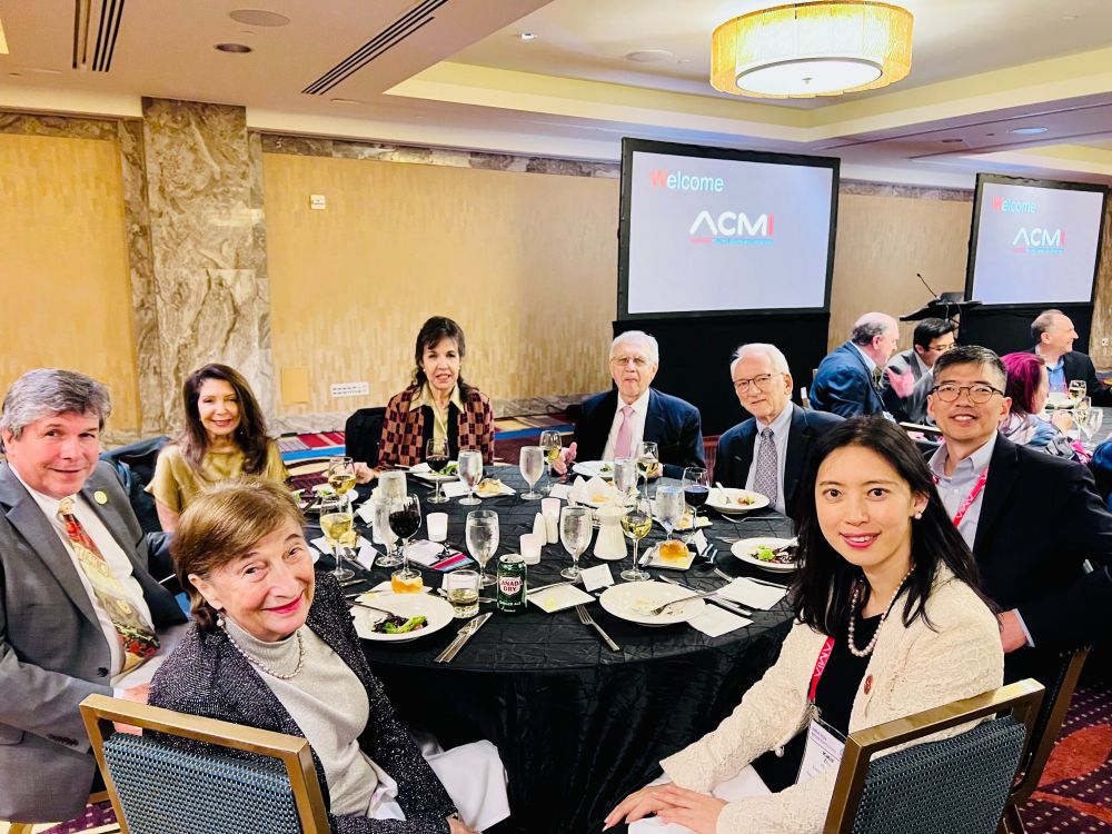Photo of people seated around table at AMIA 2024 annual meeting (American College of Medical Informatics induction ceremony).