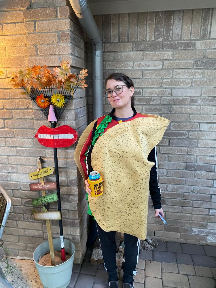Me in a taco costume next to a rake my mom dressed up as an autumn wraith