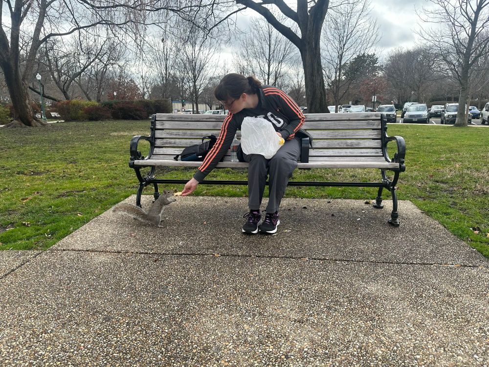 Me on a bench sharing some sandwich with a squirrel