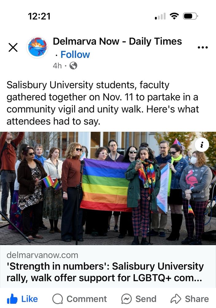 Screenshot of a Facebook page for DelMarVa Now and a photo of women and a few men holding a pride flag behind a woman speaking at a microphone. 