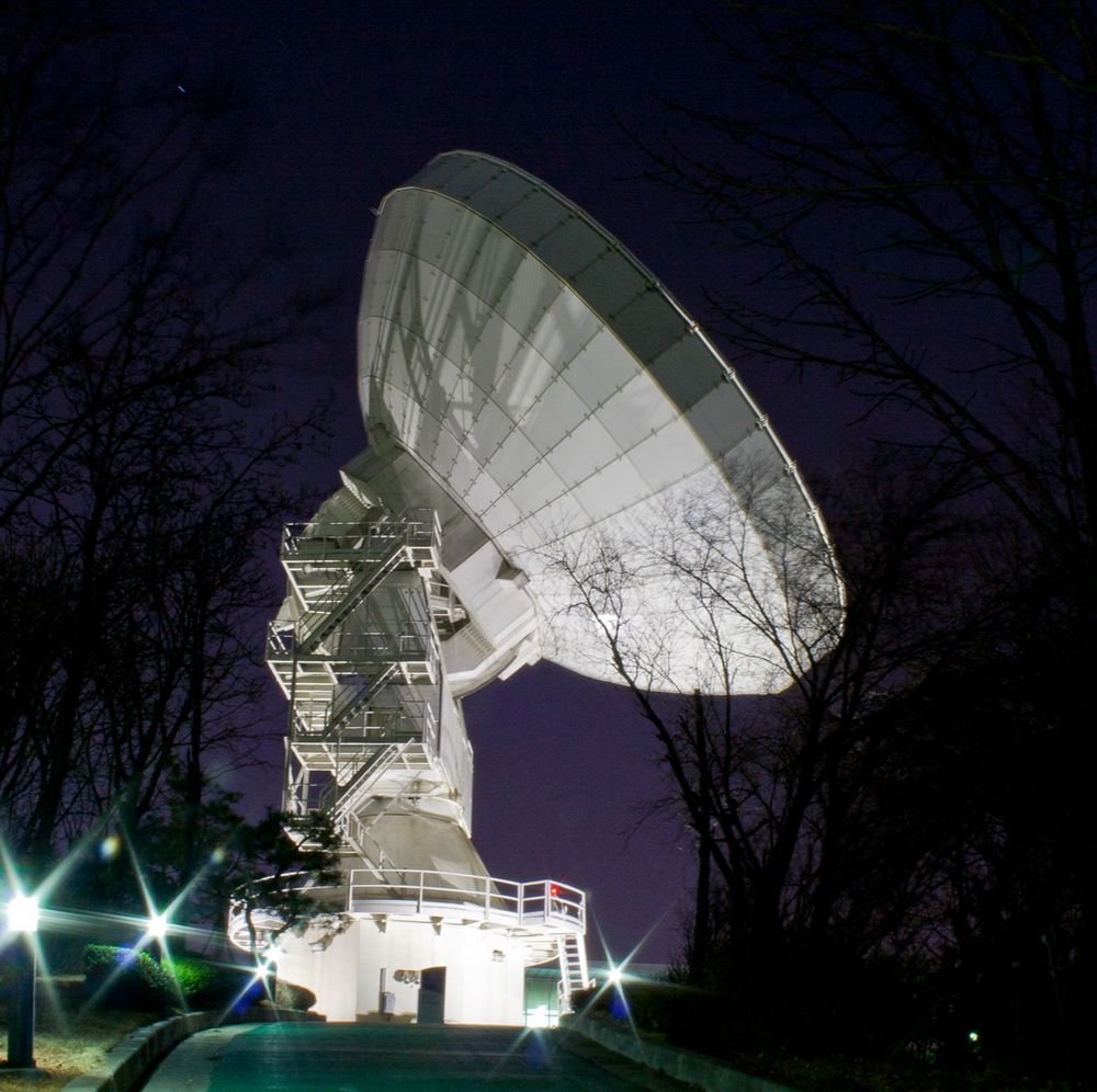 A side-angle of the KVN Yonsei telescope, with a purple sky in the background