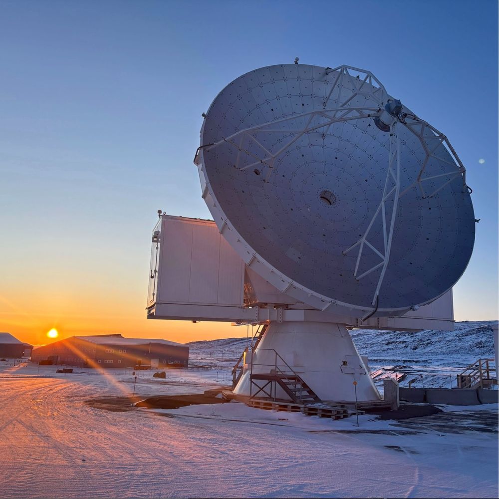 The Greenland Telescope, sitting on snow, with a sunset in the background