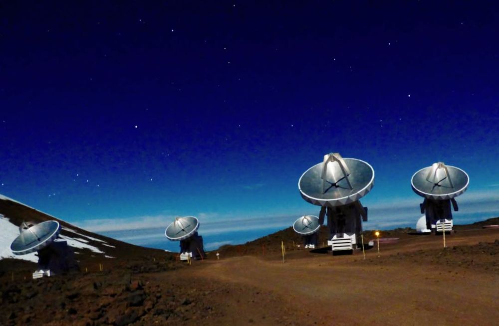5 of the radio dishes in the SMA, set against a dark blue sky and brown dirt ground.