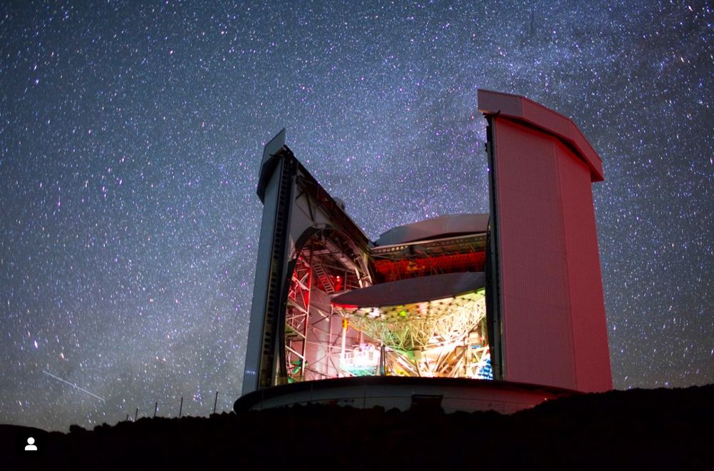 The James Clerk Maxwell Telescope underneath a starry blue-black sky