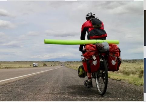Photo of cyclist carrying a pool noodle to encourage cars to leave space for them. 