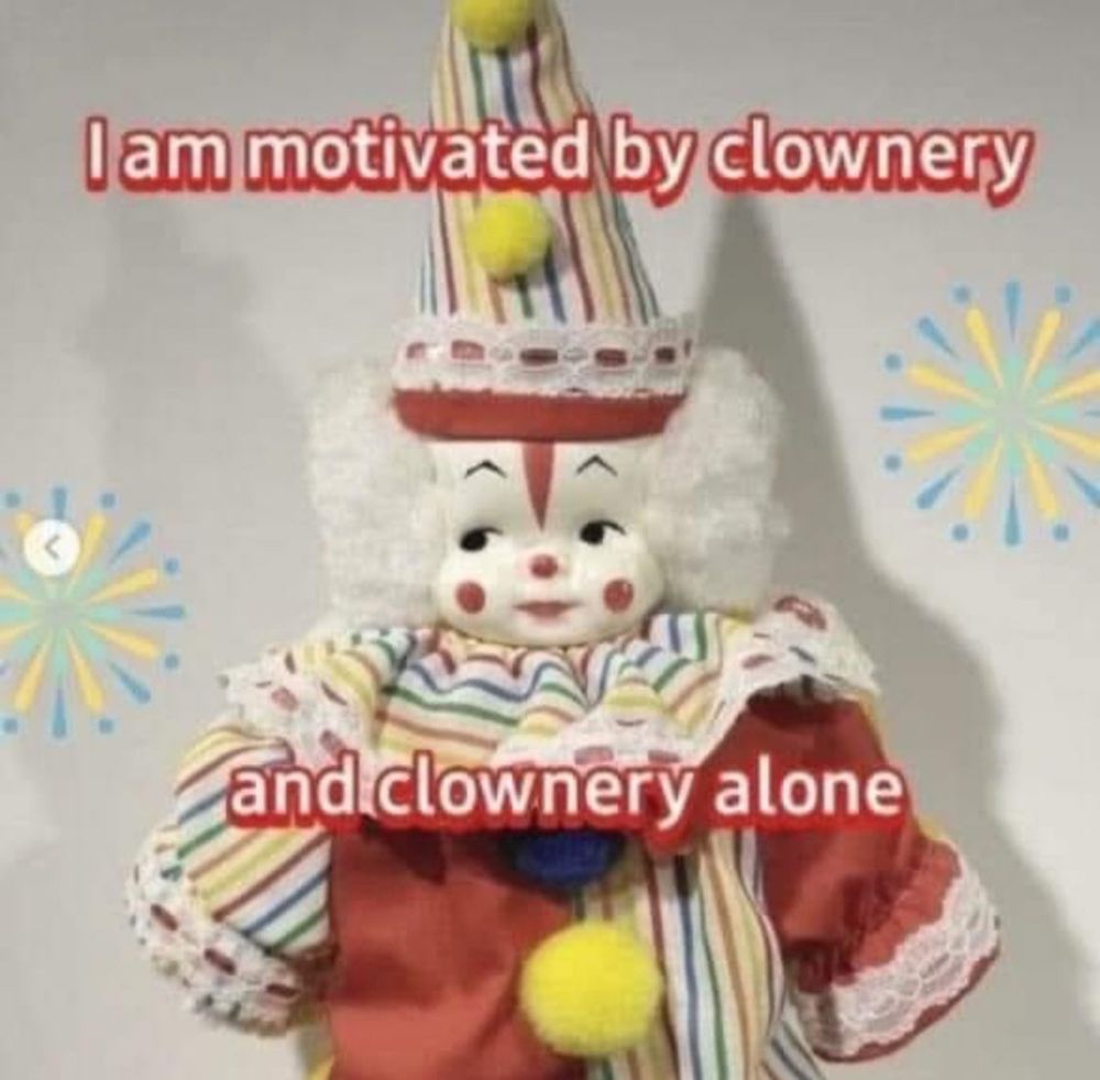 a small clown doll with red and white text that states I am motivated by clownery and clownery alone.
