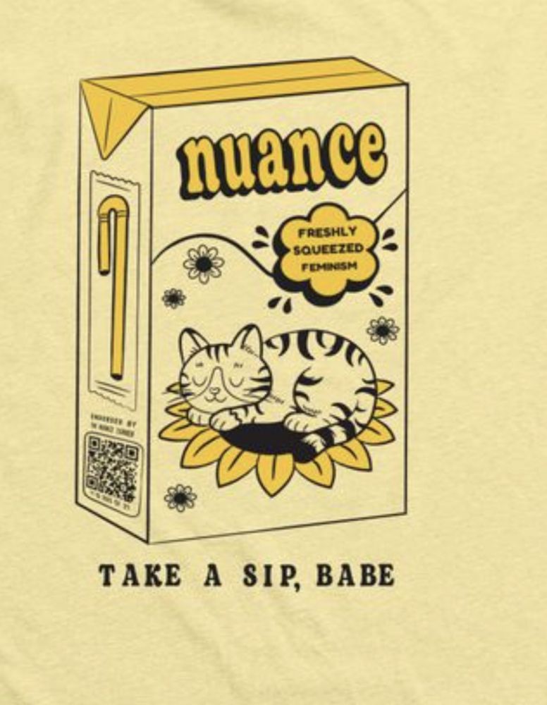 A tee shirt of a juice box with yellow details. It says nuance on top, there's a little bubble that says freshly squeezed feminism, and a cat sleeps on a sunflower. 