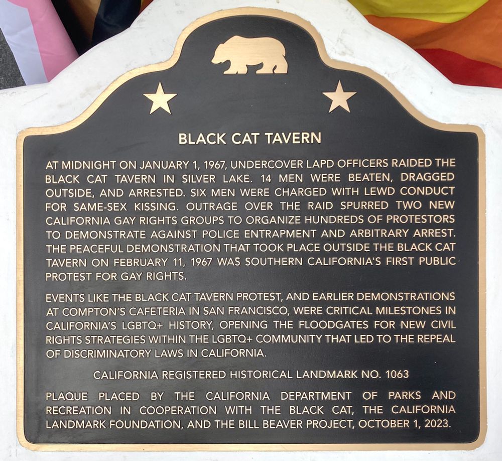 At midnight on January 1, 1967, undercover LAPD officers raided the Black Cat Tavern in Silver Lake. 14 men were beaten, dragged outside, and arrested. Six men were charged with lewd conduct for same-sex kissing. Outrage over the raid spurred two new California gay rights groups to organize hundreds of protestors to demonstrate against police entrapment and arbitrary arrest. The peaceful demonstration that took place outside the Black Cat Tavern on February 11, 1967 was Southern California's first public protest for gay rights.

Events like the Black Cat Tavern protest, and earlier demonstrations at Compton's Cafeteria in San Francisco, were critical milestones in California's LGBTQ+ history, opening the floodgates for new civil rights strategies within the LGBTQ+ community that led to the repeal of discriminatory laws in California.

California Registered Historical Landmark No. 1063.

Plaque placed by the California Department of Parks and Recreation in cooperation with The Black Cat, the California Landmark Foundation, and the Bill Beaver Project, October 1, 2023.