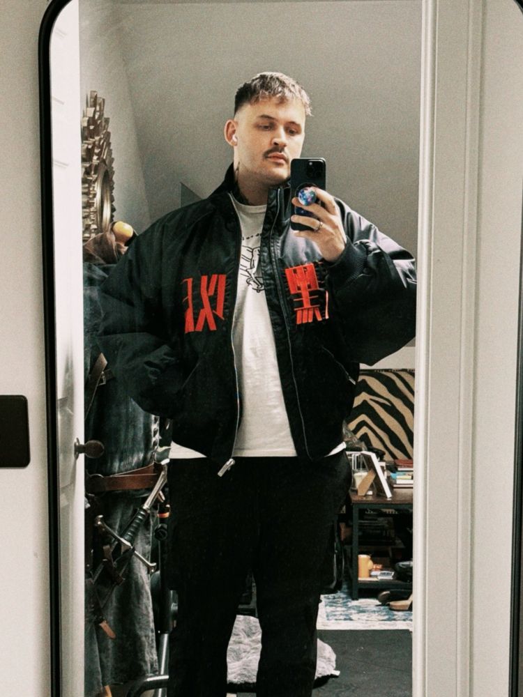 Me, a dork, standing in front of a mirror in my messy flat, pretending to be cool. I’m wearing my friend Liam Wong’s sick bomber jacket from his After Dark: Chapter 2 collab with ARK/8.