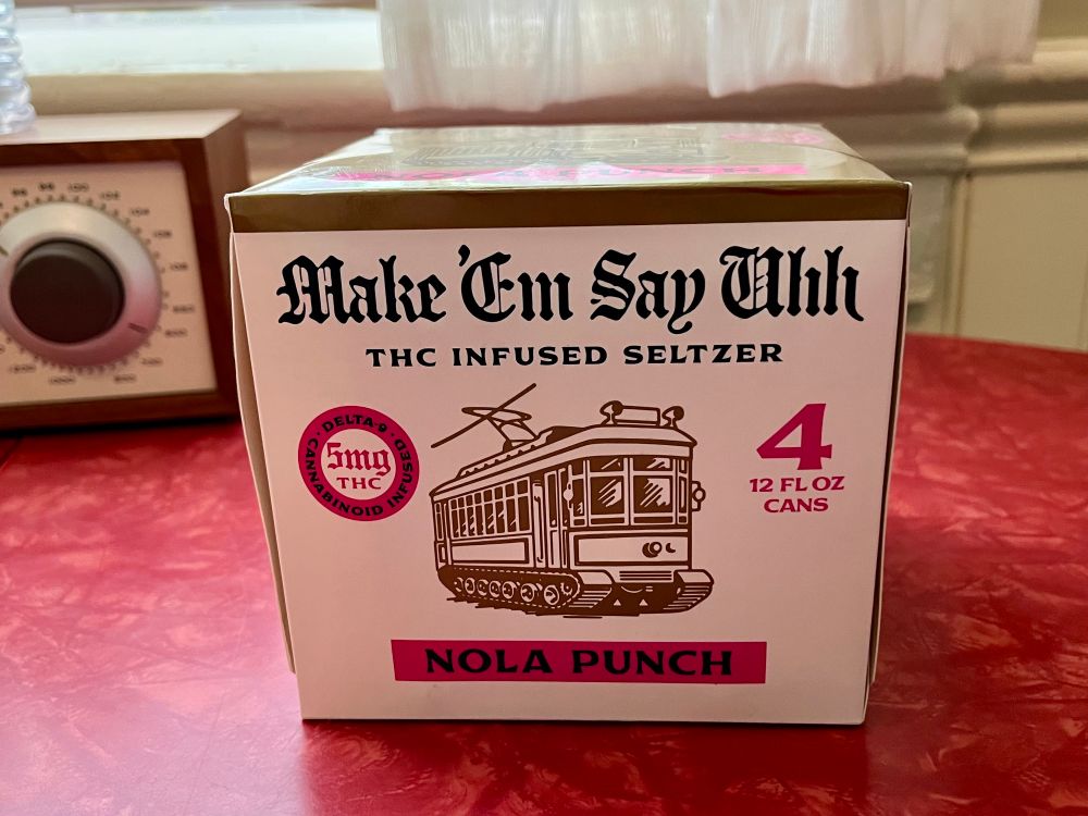 Photo of a four pack of seltzer sitting on a red table. The packaging reads:

Male ‘Em Say Uhh
THC INFUSED SELTZER
[drawing of a streetcar]
NOLA PUNCH