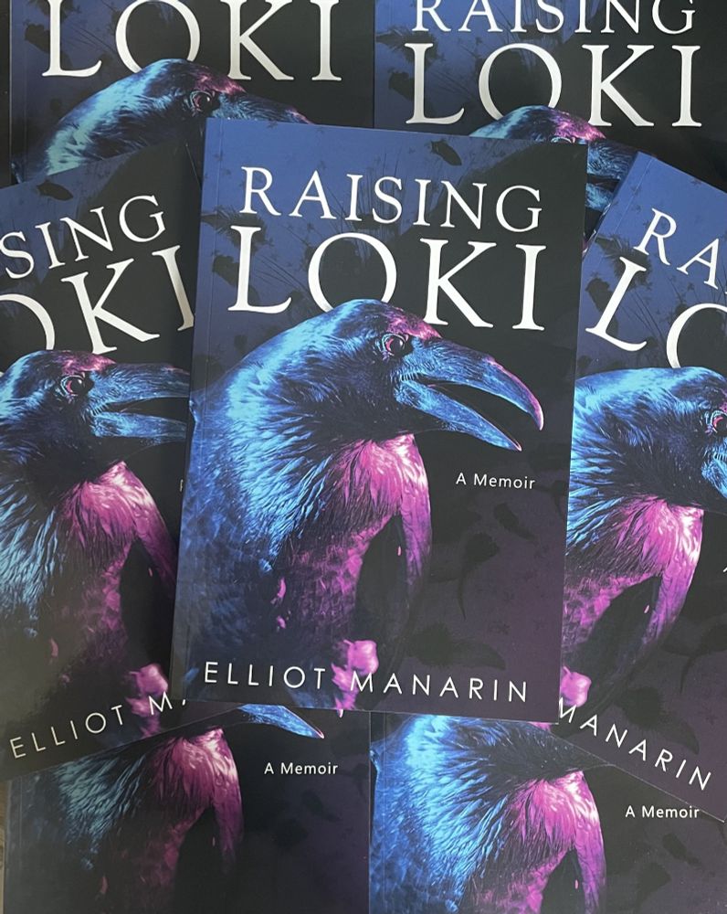 Image of multiple copies of Raising Loki, a book by Elliot Manarin, stacked together. Book cover shows Loki the Raven, with the words "A Memoir."