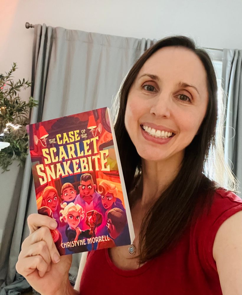 Christyne holding ARC of THE CASE OF THE SCARLET SNAKEBITE 