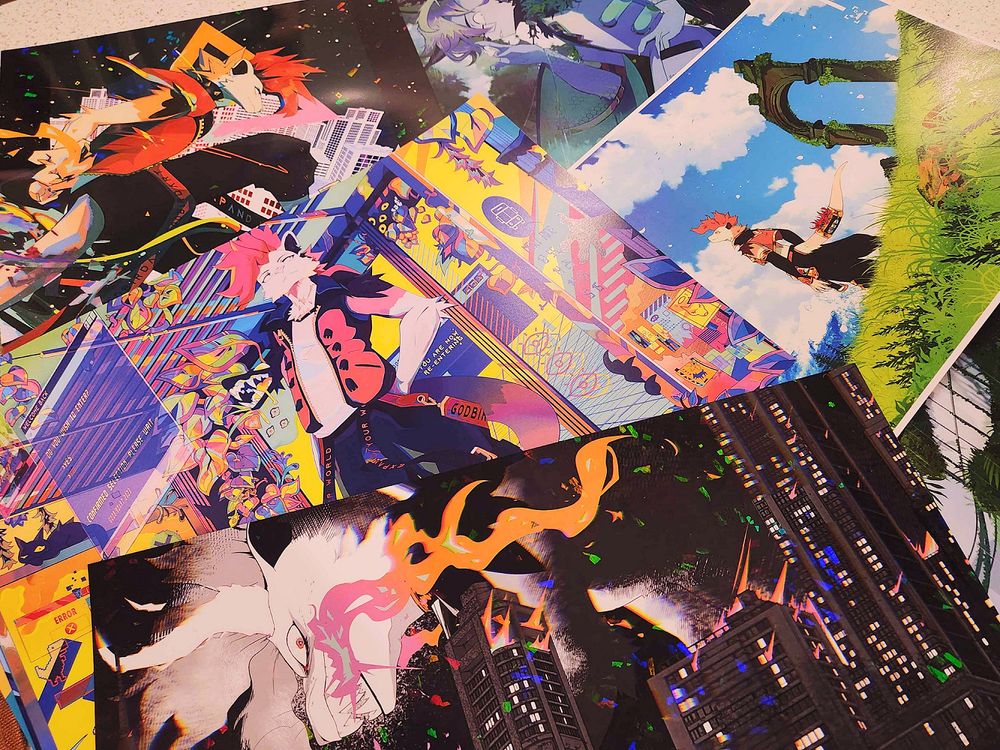image is a photograph of a variety of art prints featuring the artist's anthropomorphic characters. 