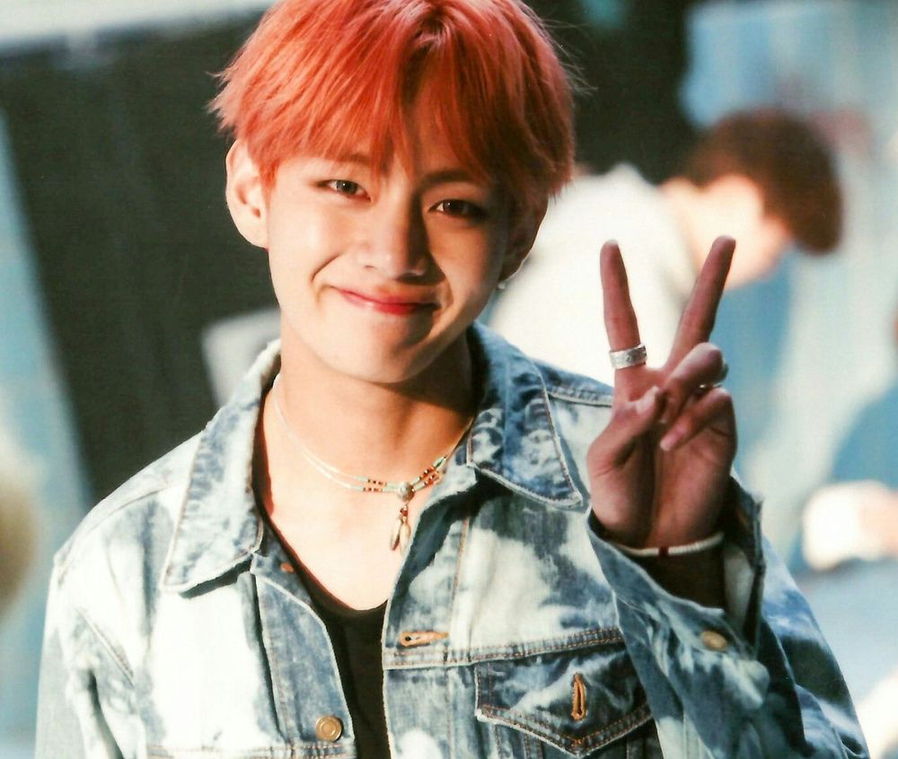 Dark pinkish red hair Tae with his V sign, bluejean jacket, black shirt beneath, sweet toothless smile, a precious soul. 
