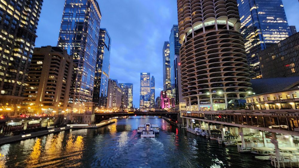 Photo of the downtown Chicago river with a tour boat passing through.
