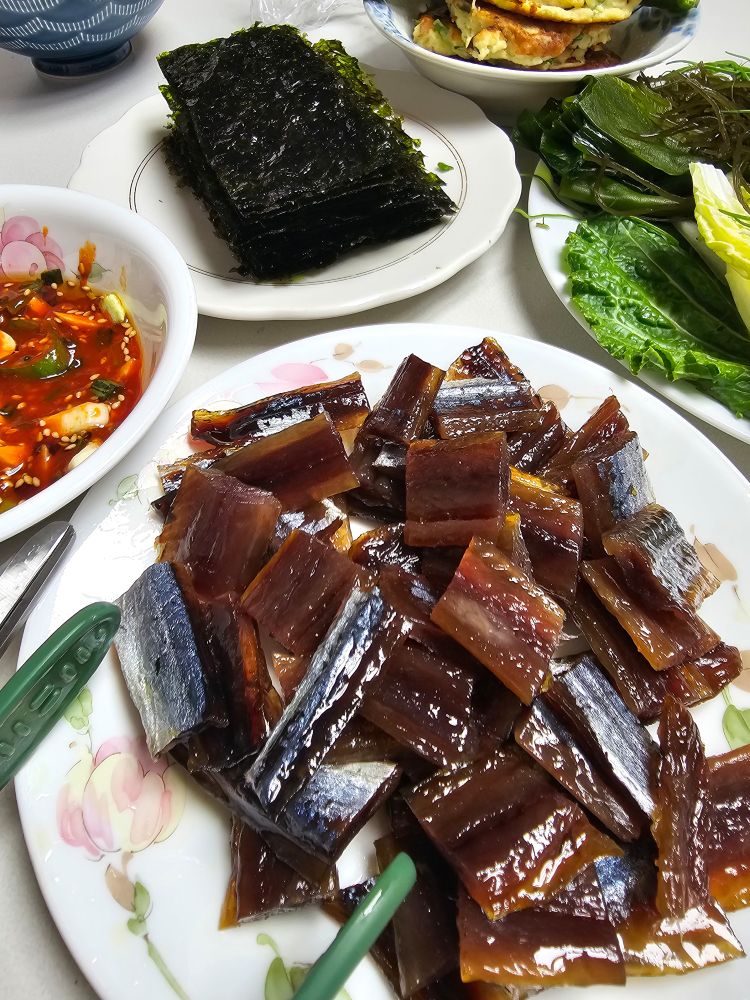 잘라놓은 과메기가 담긴그릇. 왼쪽위부터 오른쪽으로 초장. 김.두부전. 야채그릇이 늏아져있음