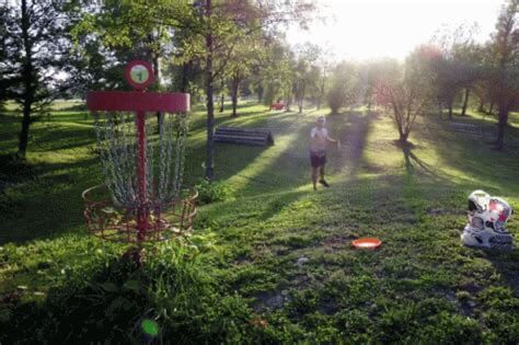 Image of a kid throwing a frisbee into a large chain-wrapped goal