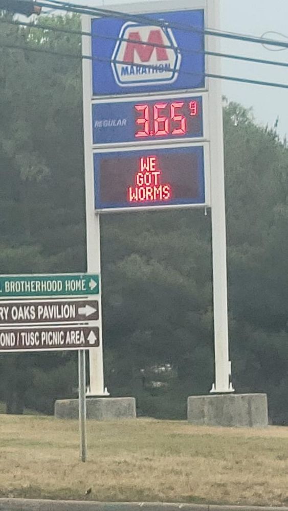 marathon gas station sign that says "we got worms" 