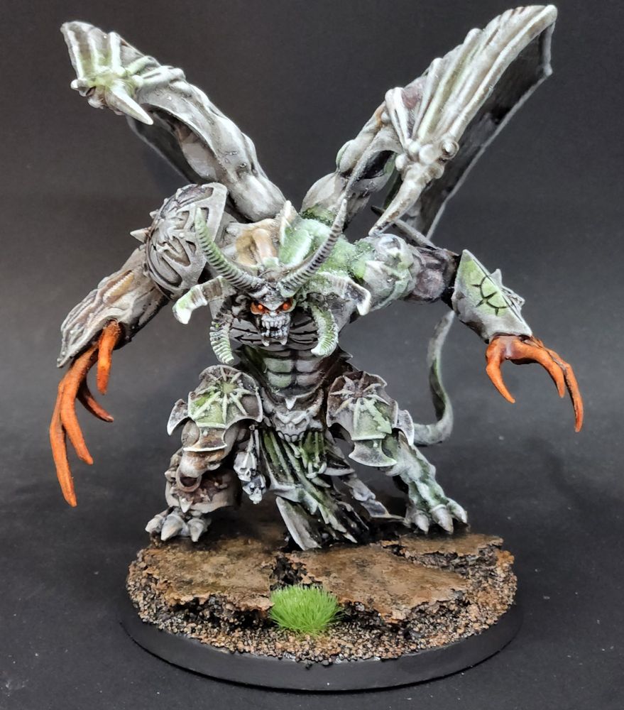 A winged daemon prince of chaos painted like a statue/stone with orange energy effects. 