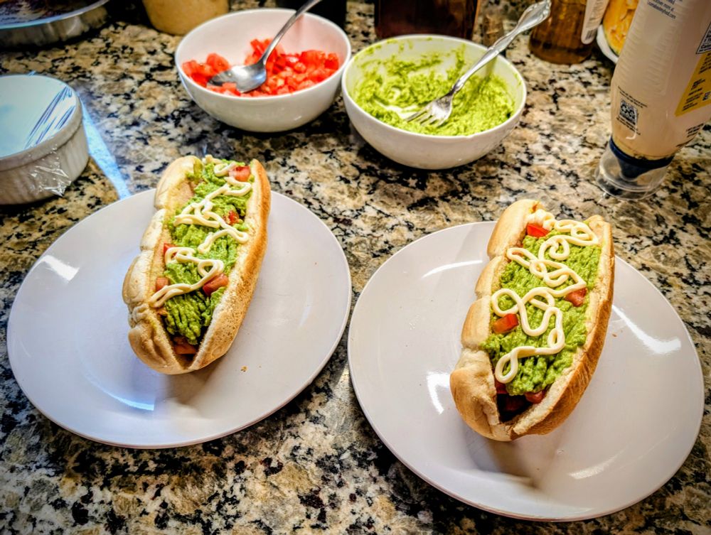 A staple of finger food in Chile, a "Completo italiano" is almost a full meal in itself. It's the most popular type of completo, and it has nurtured at low cost many generations of college students without the means or the time to access a more proper meal. There are different ingredients for completos: sauerkraut (called "chucrut" in Chile), salsa americana (a type of finely minced giardiniera), salsa verde (onion and cilantro), and others.

The most important aspect of Chilean completos is the quality of the ingredients. Good sausages and bread are a must. Chileans, when they visit the USA, refuse to eat the unappealing, over-processed offal that is presented as hot-dogs here. An actual quote from a Chilean visitor: "The humblest completo from the poorest gas station in Chile is better than any hot-dog you can find in the USA". I'd have to agree.

To make Chilean completos, you must find high quality sausages, the fewer preservatives and extraneous chemicals the better (tip: they are never cheap). As for bread, good sub buns will work, especially if they are brioche or a similar French type; even a good baguette will do in a pinch. For the basic garnishes, try tomatoes (finely diced), mashed avocado with a pinch of salt and a splash of olive oil, and good mayo (home made goes incredibly well). Other than Italiano, my favorite garnishes are sauerkraut with mayo and Dijon mustard.