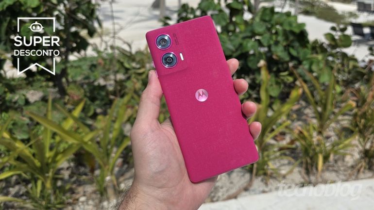 Mão segurando Motorola Edge 50 Fusion com vegetação ao fundo