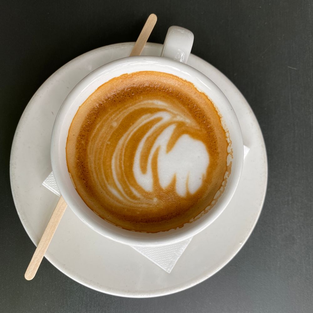 Image of a coffee cup with milk as seen from above. 