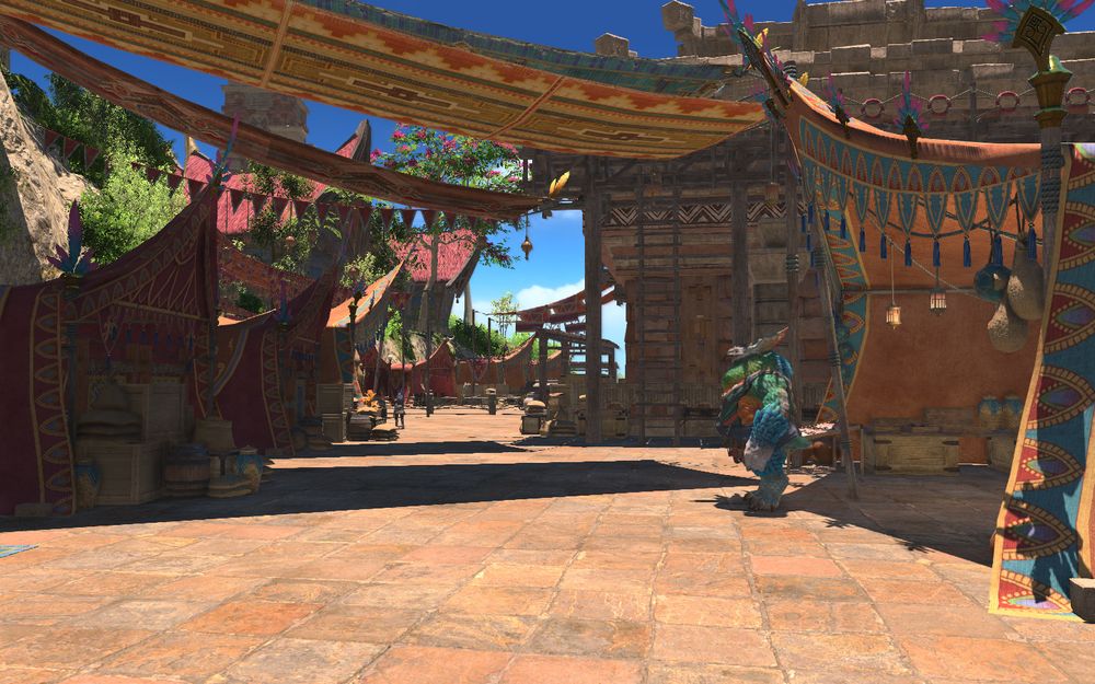 Screenshot of Wachumeqimeqi in Final Fantasy XIV. A latino inspired port area with bright skies, establishments draped in red colours and water nearby. A fantasy bird person can be seen to the right.