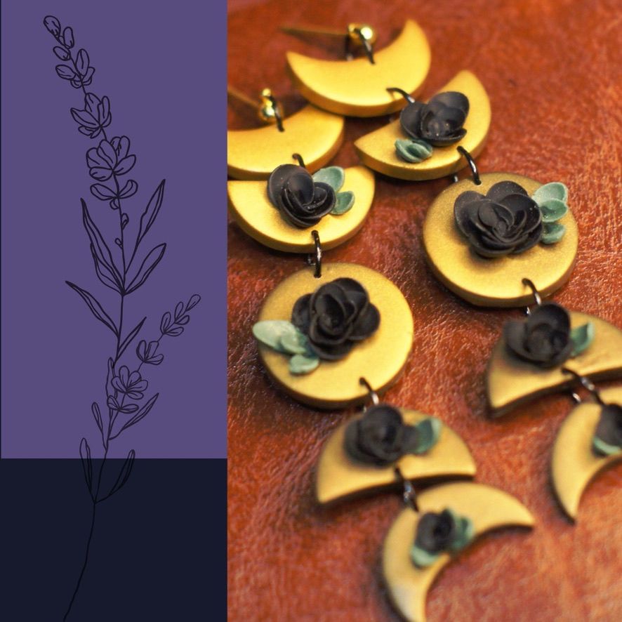 photo has a panel on the left in purple with a black floral doodle on it, along side there's a photograph of a pair of polymer clay earrings, the earrings are gold moon phases with a lustre to them, each moon phase segment has a black rose with sage green leaves on the front. the segments are joined together with black jump rings and the earrings are sitting on a brown leather background.