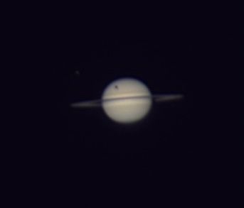 You can see Titan’s shadow on the upper left of Saturn.  In my next picture taken about 30 min later, you can see the shadows moved towards the center of Saturn, due to the orbit of Titan, wrt the location of the sun.

My 3rd pic is purposely over exposed to show the moons Rhea (far left), Titan left high above the rings, and Dione (right immediately above the ring).

Titan is the 2nd largest moon in the solar system (Jupiter’s Ganymede is the largest).  To put that in perspective, Titan is larger than the planet Mercury.

The 15-year-ish cycle is due to Saturn’s tilt on its axis, so like Earth, it has seasons.  Its long slow orbit around the sun account for the long cycle.  So for a shadow to be seen from Earth, Titan must be in just the right spot.  

Titan orbits Saturn once every 16 days, so we actually get to see the shadow about a half dozen times on a 16 day cycle during the transit year.  Then Saturn’s tilt changes enough and the shadow no longer hits Saturn. Aug 29, Sept 4, and Sept 20 are the last chances to see the transit.  You will need a pretty good telescope, however to see the shadow.  I tried my 4” 900 mm refractor, but was disappointed.

Tech stuff:
Scope 11” SCT focal length 3000 mm
Mount: ZWO AM5N
Camera:  ZWO 533MC
Video:  about 40% of 2000 frames stacked 