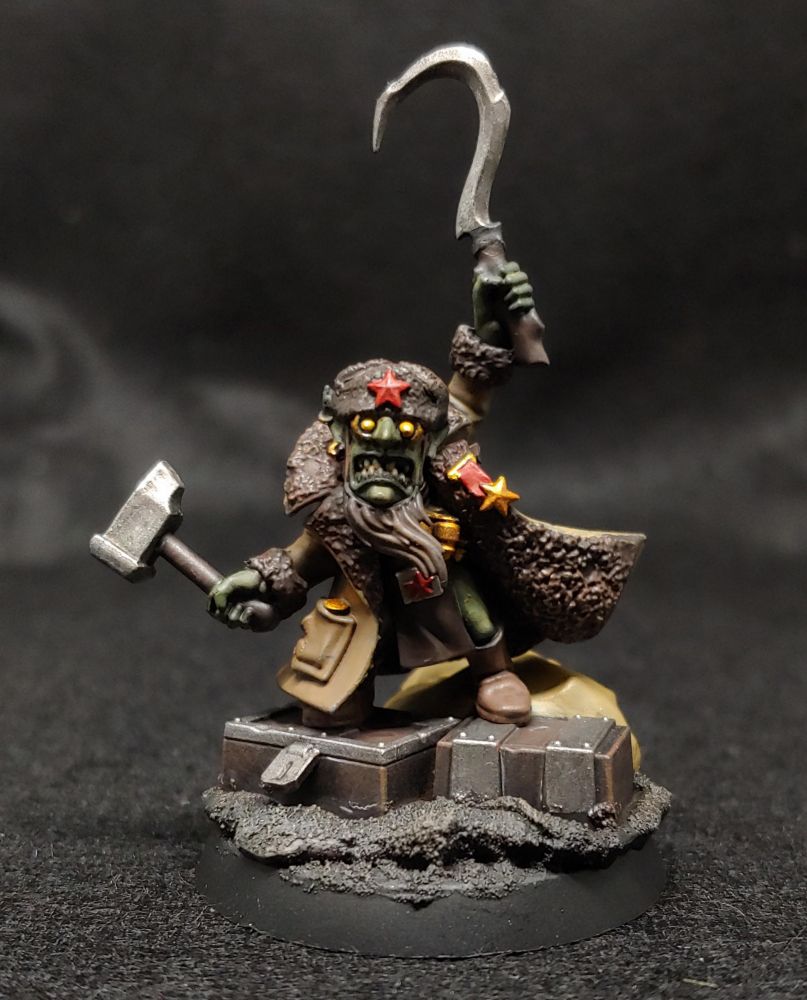 The red gobbo, a warhammer model of a small goblin character dressed as a Soviet commissar, holding a hammer and sickle.