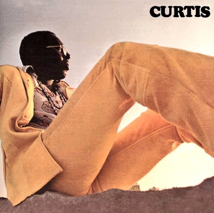 Curtis Mayfield wearing a yellow suit on the cover of his 1970 debut album, Curtis.