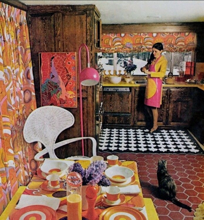 A woman and a cat in a 1970s kitchen