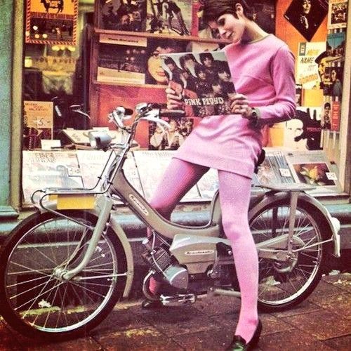 A model wearing all pink sitting on a moped in front of a record store looking at Pink Floyd's album The Piper at the Gates of Dawn in 1967