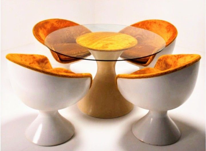 Chromcraft's 1973 Pacemaker Series, space age modular sofa and pod chairs in houndstooth, yellow, and orange upholstery on white pedestals. Glass top round tables with tulip bases also featured.