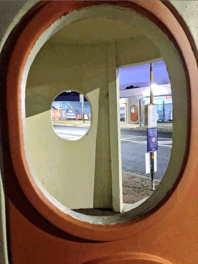 A view through one of the two orange porthole window openings