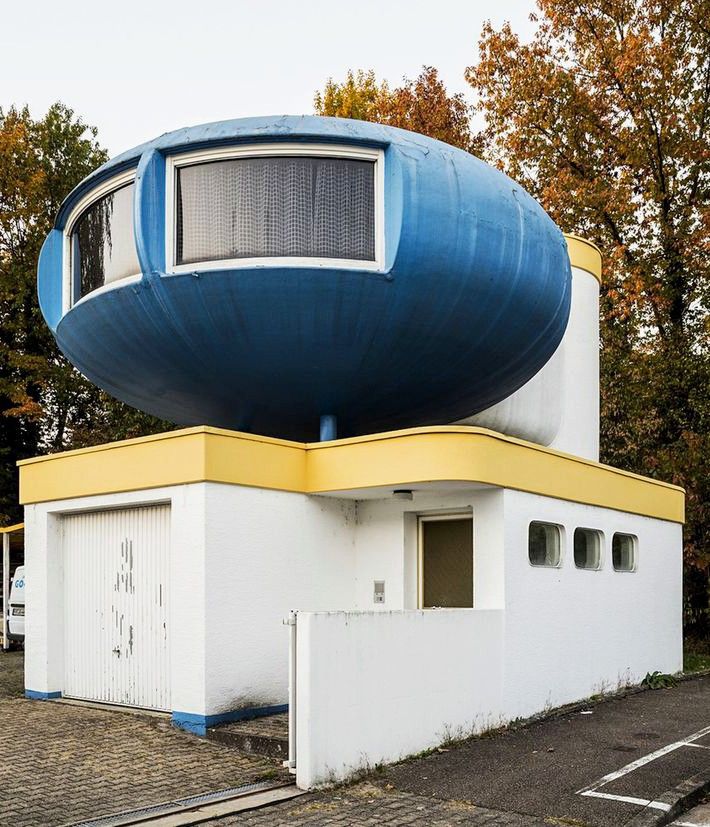 Space age UFO shaped dwelling structure designed by architects Angelo & Dante Casoni, originally built in 1969 by Horlacher and exhibited (in white) at the Basel Model Fair, and the "ika '71" plastic house exhibition in Lüdenscheid in 1971. It was stored for a few years then brought to Freiburg by ship and truck in 1976 by Hans Johann Gockl, placed on a specially constructed substructure with a garage, and painted blue.