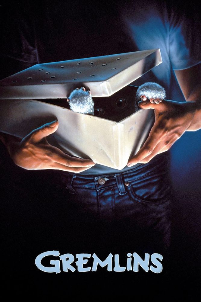 GREMLINS (1984) poster, showing a teenager holding a box with holes in the lid. The character Gizmo is opening it from the inside, with his paws lit but the rest of him shadowed inside the box.