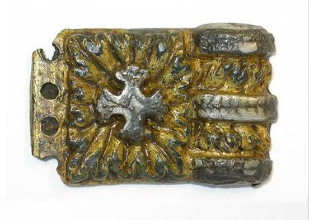 A photograph showing the front face of find TDB 1633, a gilded and silver-plated Carolingian-stype sword-strap mount made of copper alloy. This was also recovered from the site of the Viking Great Army camp at Torksey, Lincolnshire.