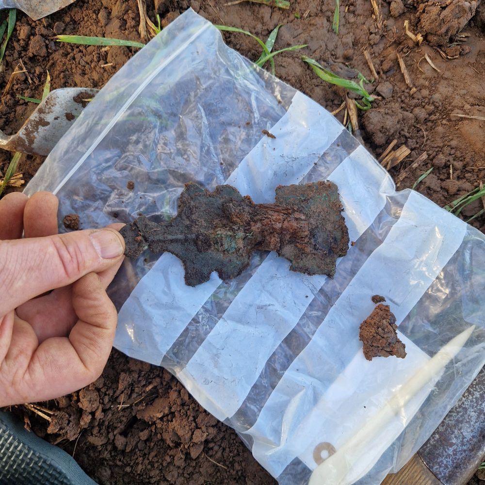 The reverse of the same brooch after lifting, showing the intact pin assembly on the back.