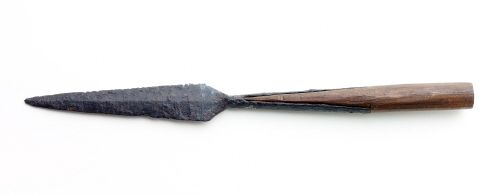 A photograph of a complete spearhead found in the Thames at Cookham. This has a clear ridge along the blade, sharply-angled-'shoulders' at the base, and a very wide split along the socket.