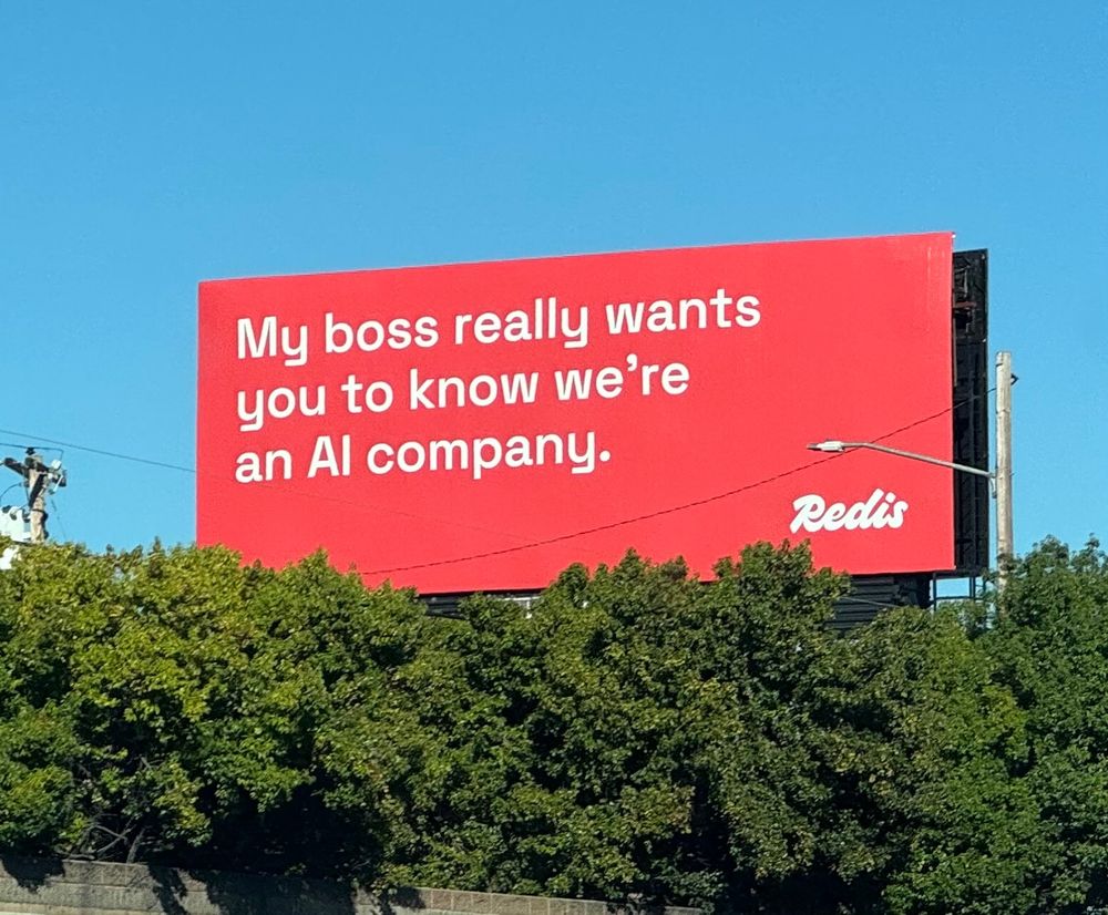A big red billboard saying “My boss really wants you to know we’re an AI company” - Redis