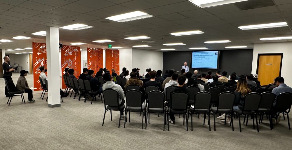 A photo showing the attendees listening to John Ousterhout's talk.
