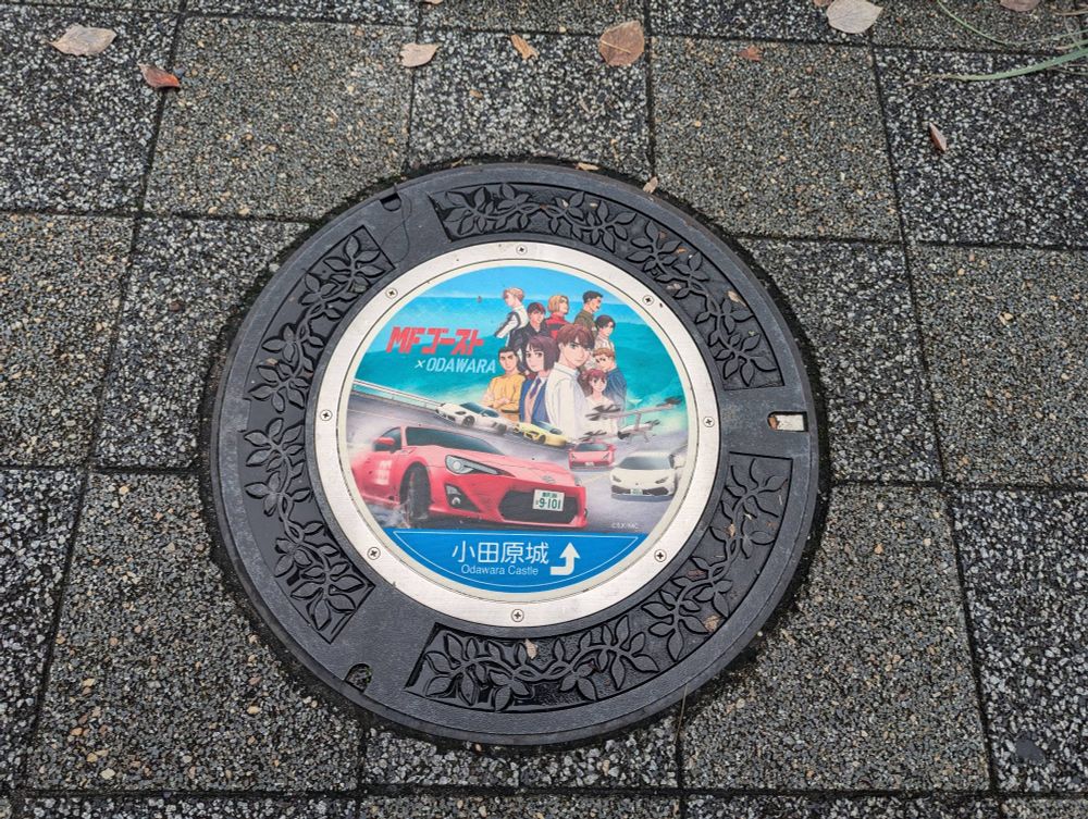 MF Ghost manhole cover in Odawara, featuring Kanata's GT86. 