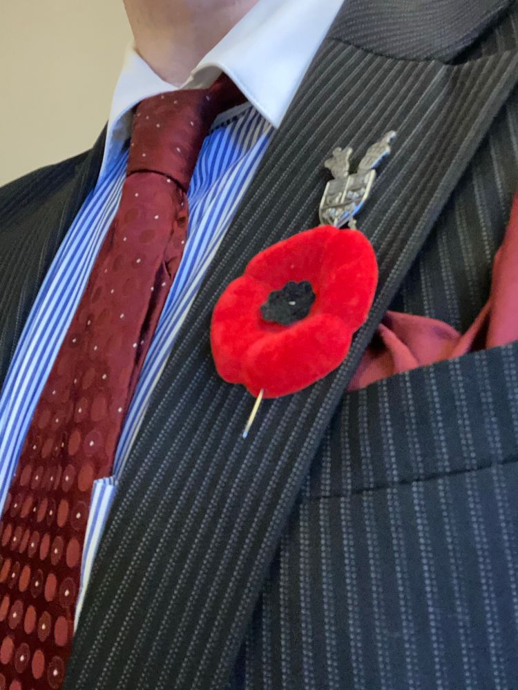 My maroon tie and pocket square framing my dark grey striped jacket lapel, which had a Parliament pin as well as a poppy, with the pin threaded through the bottom lip as described. 