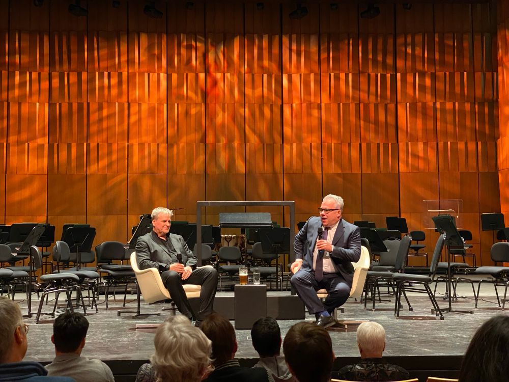 On the stage of Southam Hall, John Storgårds sits on the left and Paul Wells on the right. 