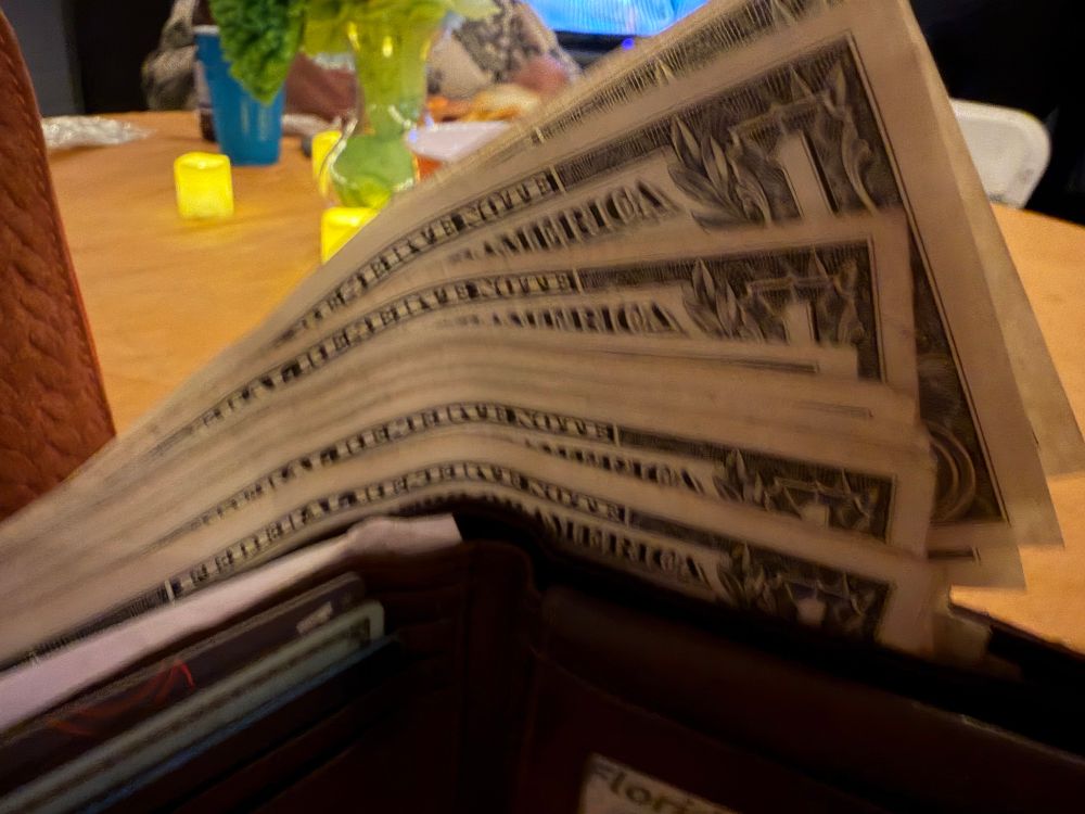 A wallet with a bunch of $1 bills in it