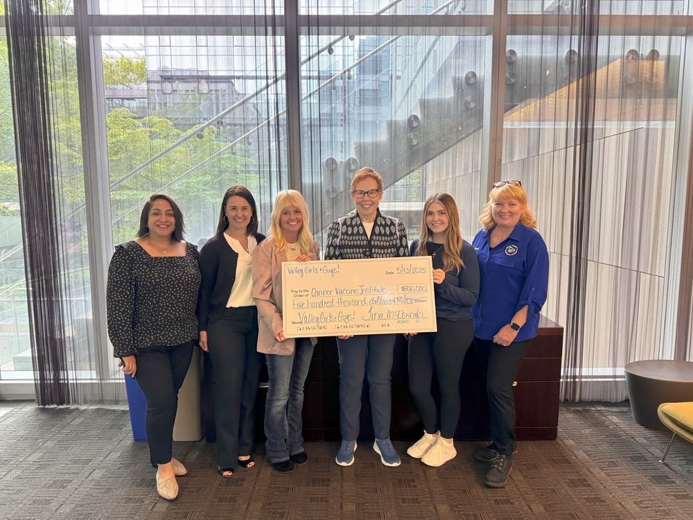 Members of the Cancer Vaccine Institute and Valley Girls and Guys hold up a large check sign for $500,000.