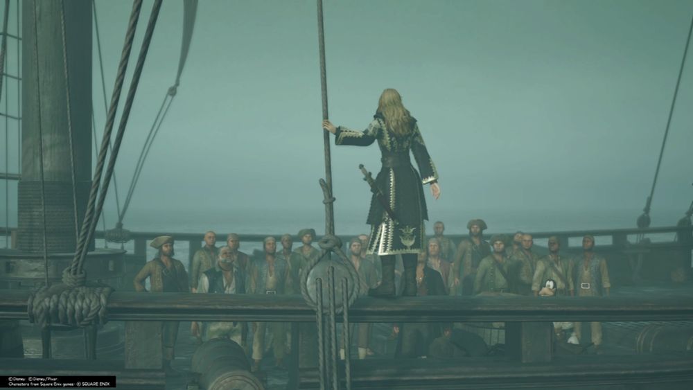 a screenshot from the pirates of the caribbean world of kingdom hearts 3. a pirate i believe to be portrayed by kiera knightley is standing on the railing of the side of a pirate ship with her back towards the camera with a crowd of pirates facing her and the camera. on the right side of the crowd, goofy's face narrowly pokes out above the railing. 